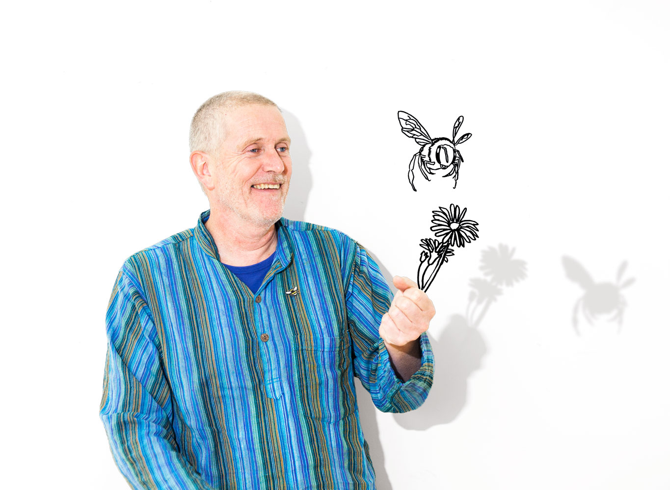 Mann mit einer gezeihneten Bienenpflanze in der Hand und einer Biene