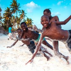 Glück - spielende schwarze Kinder am Strand