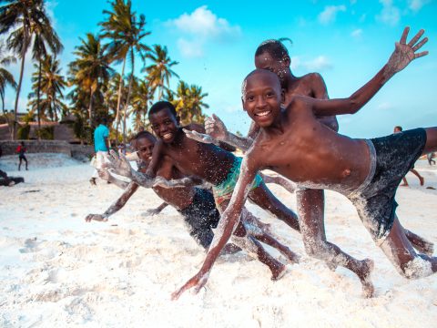 Glück - spielende schwarze Kinder am Strand