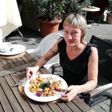 Frau am Tisch mit gemischtem Teller vom Buffet an einem Tischim Aussenbereich des veganen Restaurant Sacred.