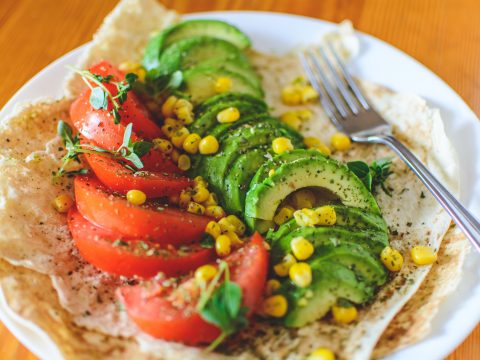 Teller mit veganem Essen: Gemüse und Fladenbrot