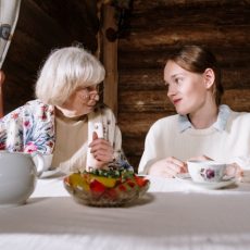 Seniorin hört sich die Sorgen eines Mädchens an beim Tee