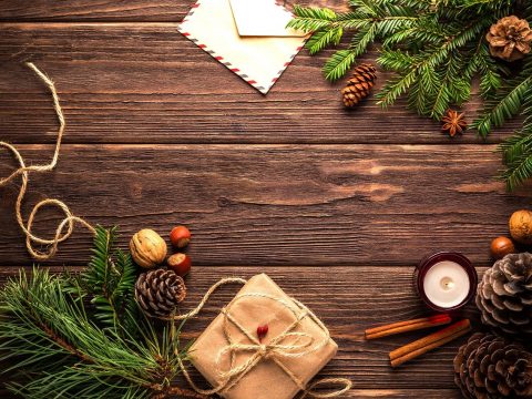Tannenäste, Rechauckerze, Tannzapfen, Geschenk in Packpapier: Symbol für nachhaltige Weihnachten