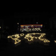 Earth Hour in Berlin: statt Strassenlampen Kerzenschein, Umrisse der Welt mit Kerzen gelegt, dahinter die Schrift Earth Hour